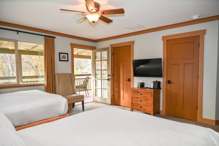 Guest House room with two full beds warm pine furnishings and French doors to veranda at Sierra Sky Ranch near Yosemite South Entrance