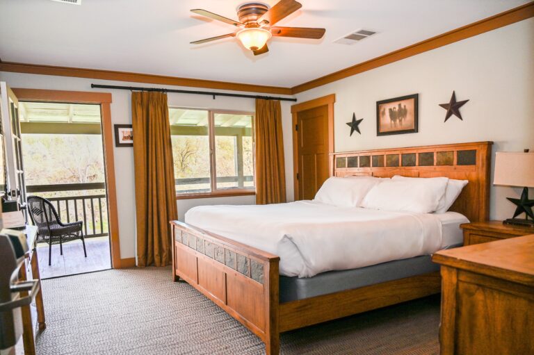 Guest House king room with warm pine furnishings echoing 150-year heritage and private veranda at Sierra Sky Ranch near Yosemite South Entrance