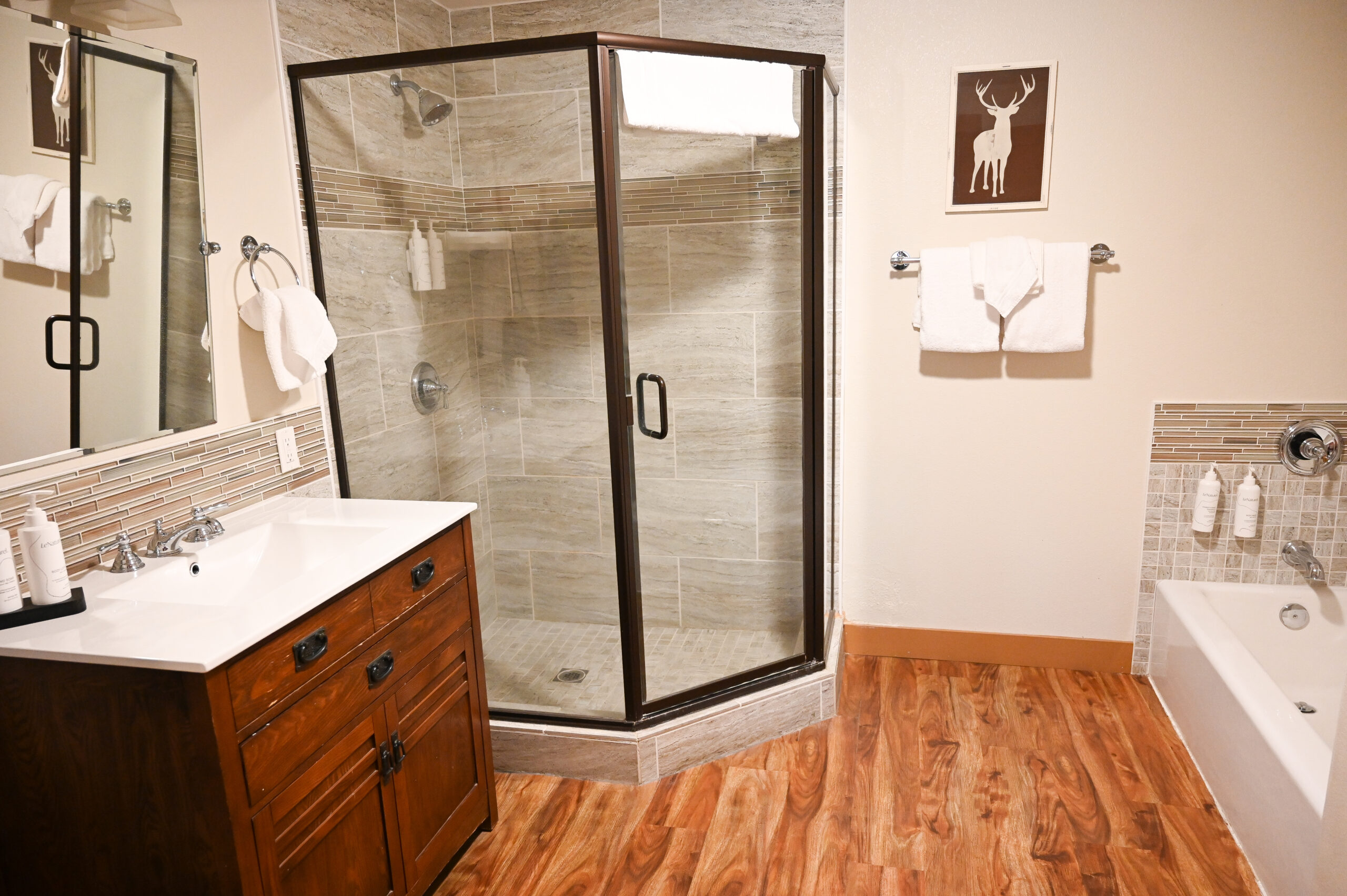 Spa-inspired 4-fixture bathroom with soaking tub and walk-in shower in two-room suite at Sierra Sky Ranch boutique hotel near Yosemite