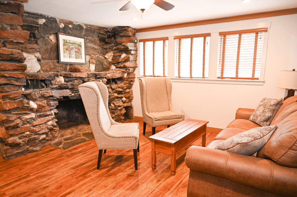 Separate sitting room with sofa bed and warm pine furnishings in two-room family suite at Sierra Sky Ranch historic hotel near Yosemite