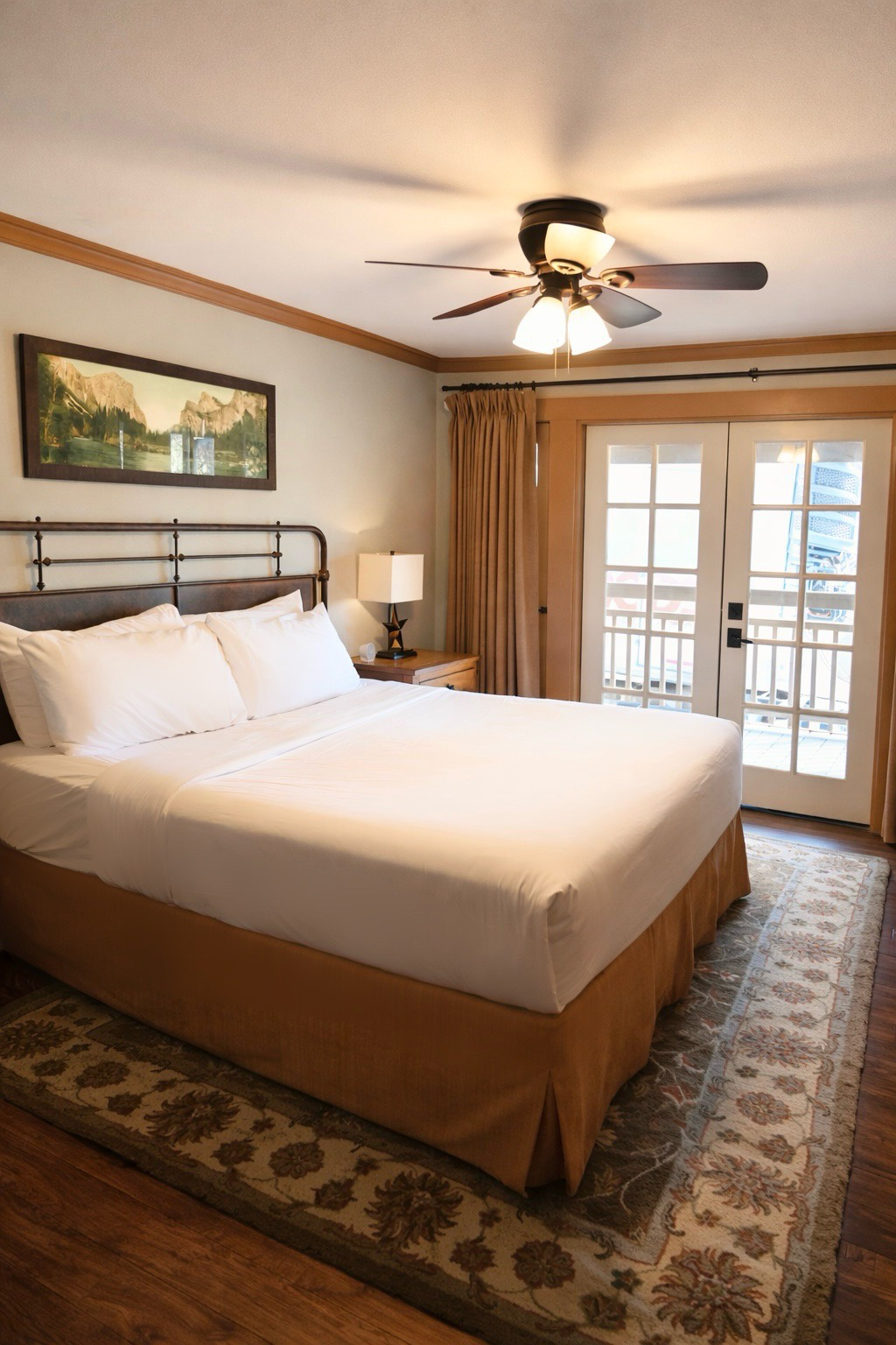 Ranch House king room with plush bed and French doors to veranda overlooking Great Lawn at Sierra Sky Ranch near Yosemite South Entrance