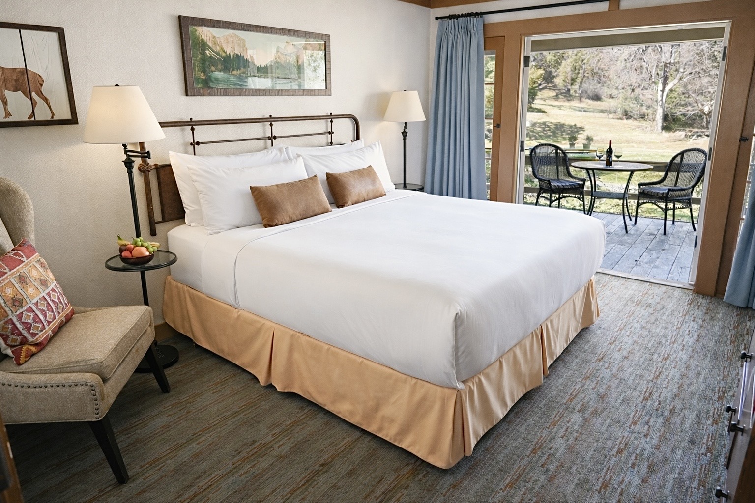 A guest room at Sierra Sky Ranch with a bed and seating in a warm, traditional setting.
