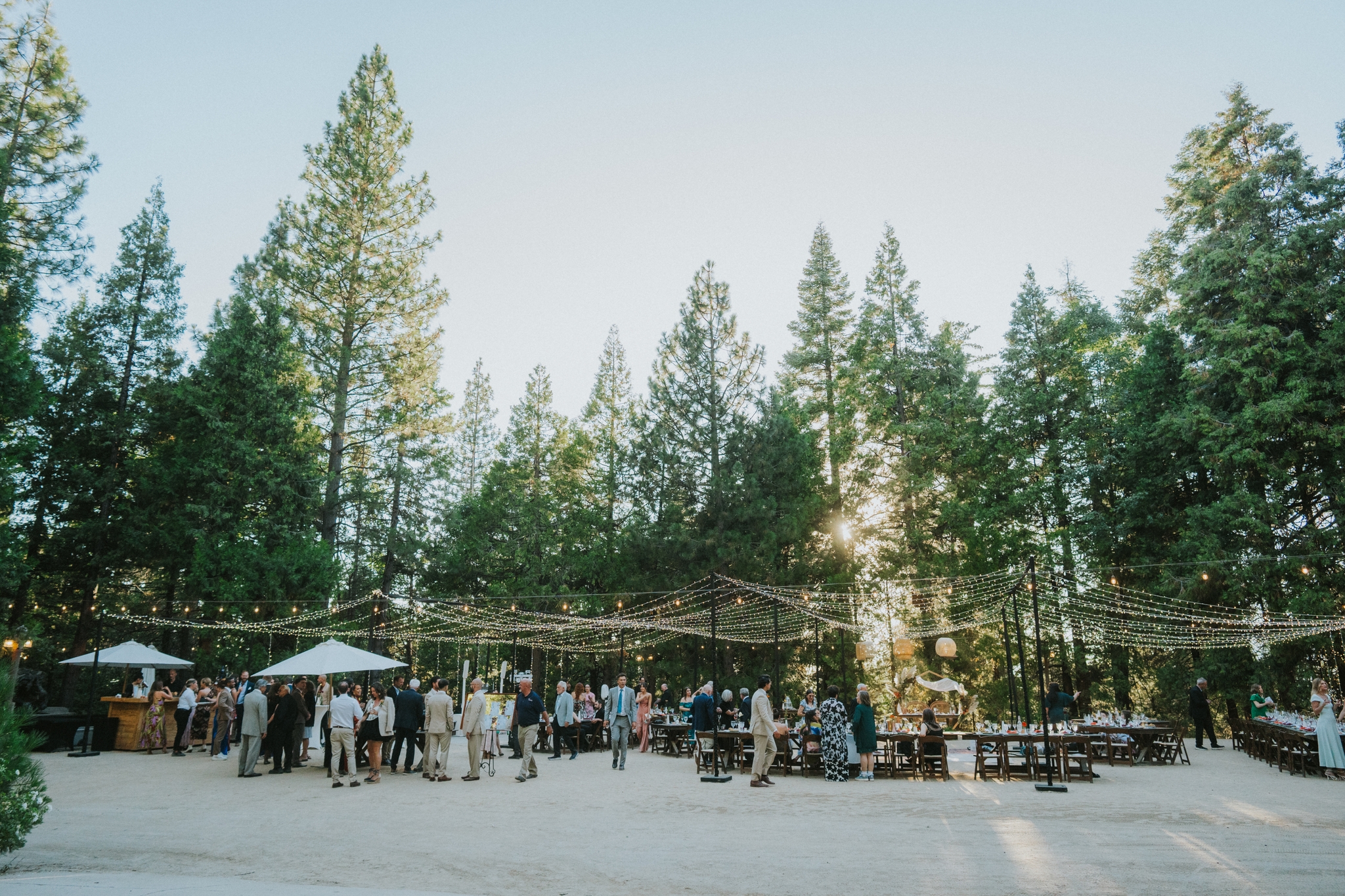 Outdoor gathering and celebration under string lights nestled in the Sierra forest at The Lodge at Two Moons