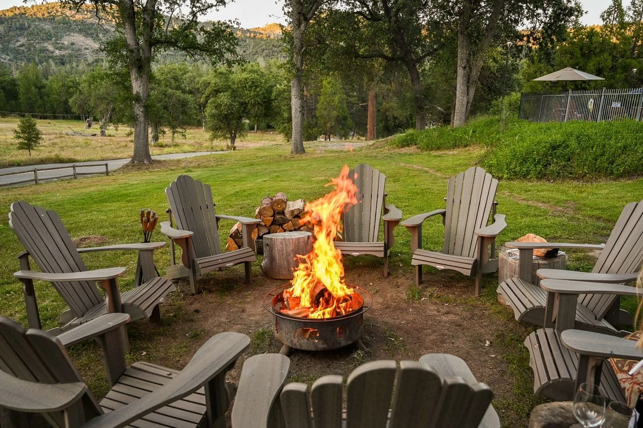 Guests gathering around the evening fire pit on the Great Lawn at Sierra Sky Ranch.