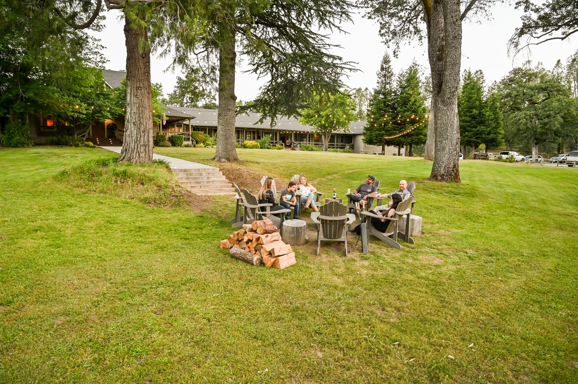 Guests gathering around the evening fire pit on the Great Lawn at Sierra Sky Ranch.